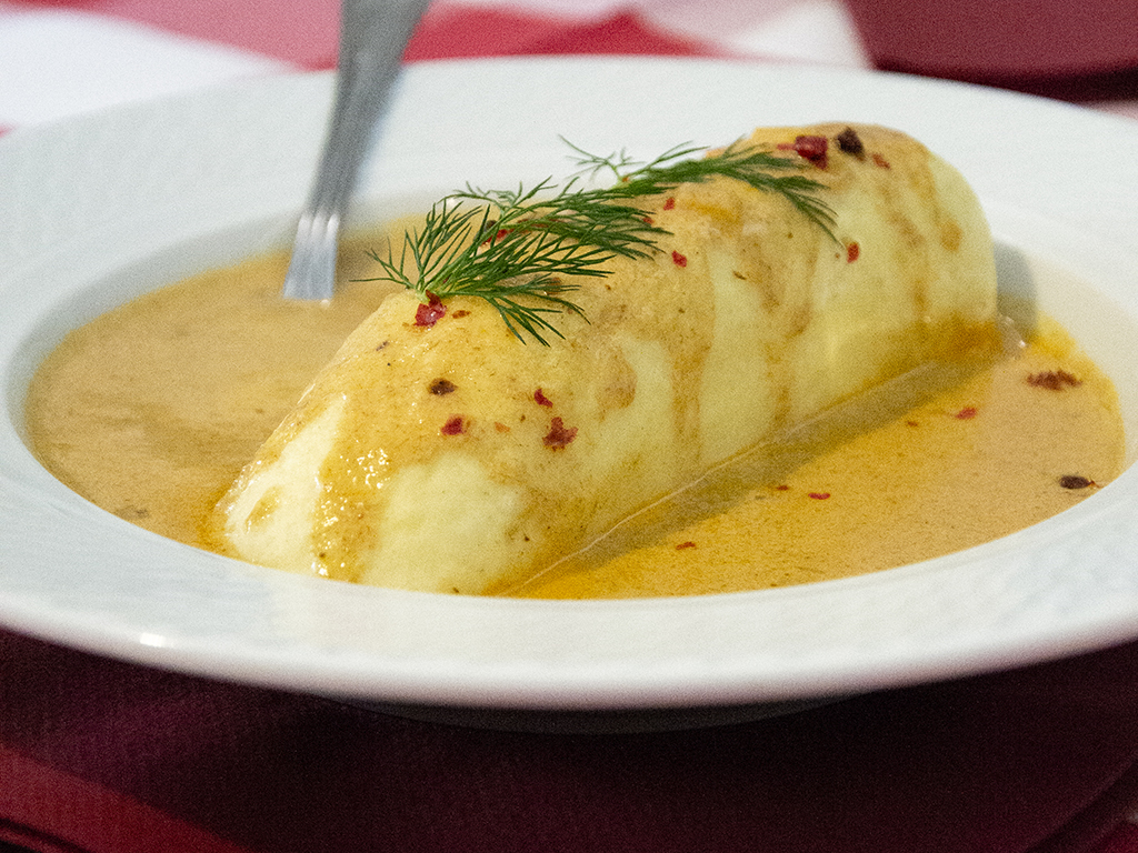 Quenelle de brochet sauce Nantua présentée dans une assiette